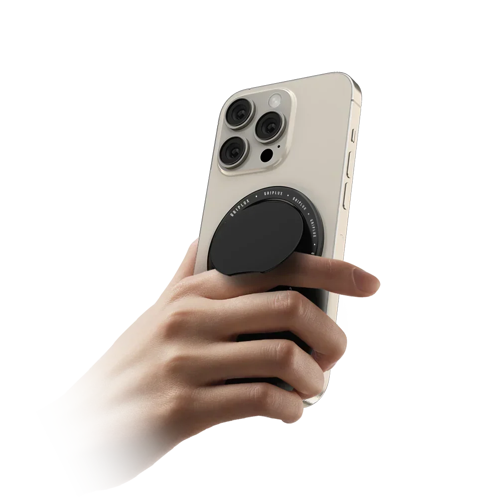 Hand holding an iPhone with a black MagSafe phone grip attached to the back, fingers hooked through the grip