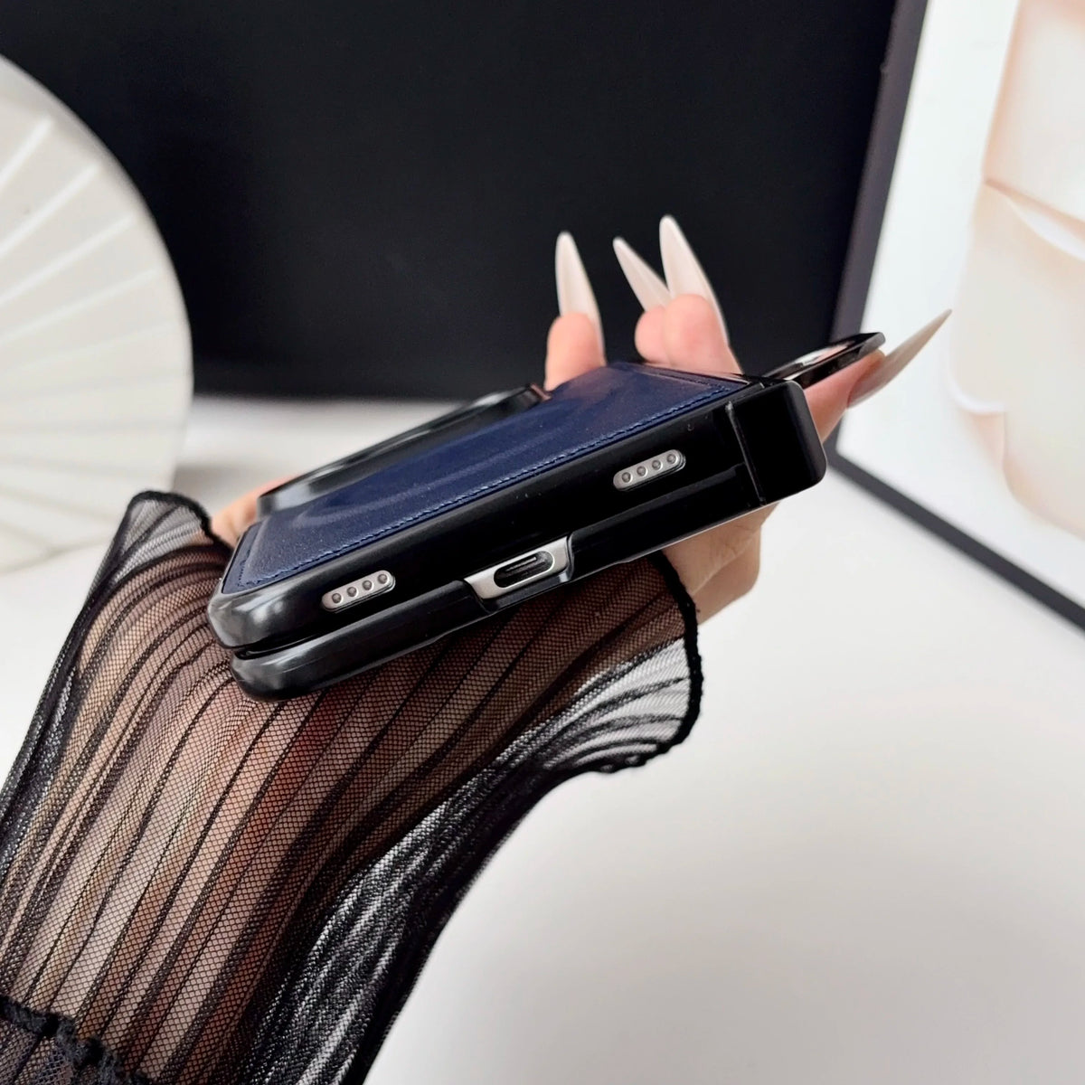 Side view of the navy leather-look case on an iPhone Duo, showing hinge and button cutouts