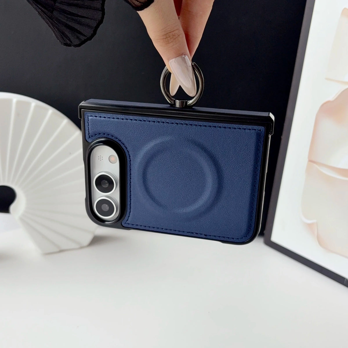 Navy leather-look MagSafe case on a folded iPhone Duo, held upright